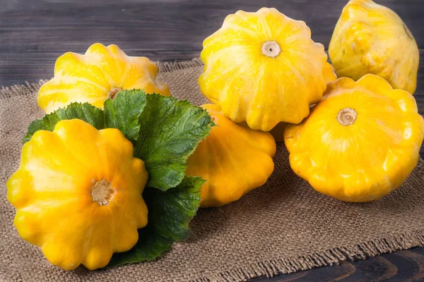 Calabaza amarilla sobre fondo de madera con servilleta de arpillera —  Fotos de Stock