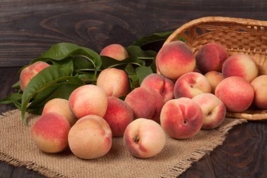 ahşap masa üzerinde bir hasır sepet şeftali