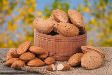 badem eski ahşap tahta üzerinde bir kasede Bahçe arka plan bulanık