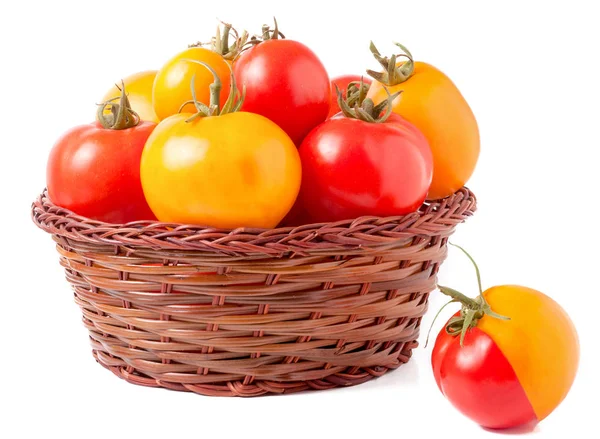 Tomates rojos y amarillos en una cesta de mimbre aislada sobre fondo blanco — Foto de Stock