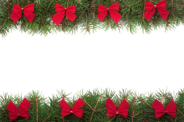 Cadre de Noël en branches de sapin décorées avec des arcs rouges isolés sur fond blanc — Photo