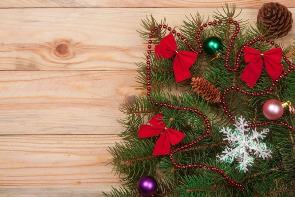 Ramo de abeto de Natal decorado em um fundo de madeira leve — Fotografia de Stock