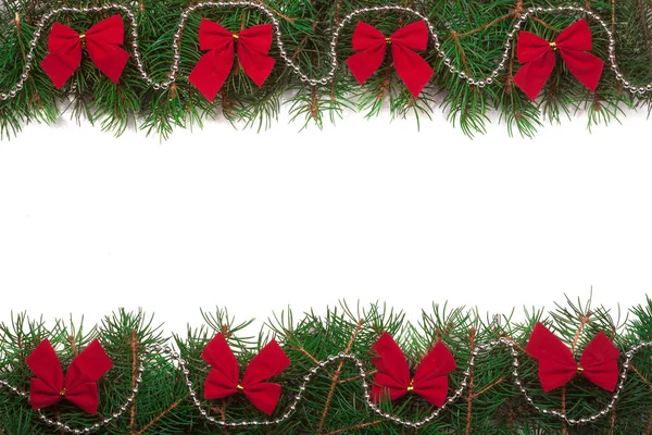 Christmas frame made of fir branches decorated with red bows isolated on white background — Stock Photo, Image