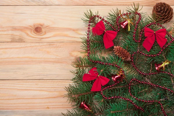 Ramo de abeto de Natal decorado em um fundo de madeira leve — Fotografia de Stock