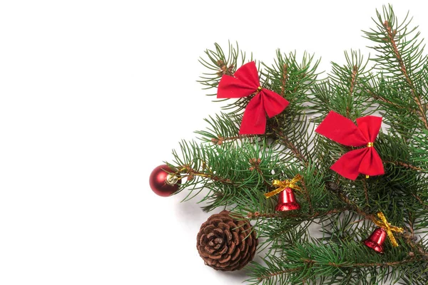 Υποκατάστημα της χριστουγεννιάτικο δέντρο με κοντές βελόνες διακοσμημένα κουδούνια και τα τόξα που απομονώνονται σε λευκό φόντο — Φωτογραφία Αρχείου