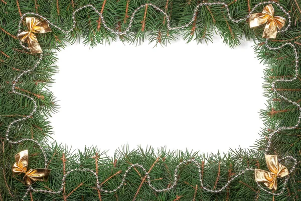 Рождественская рама из еловых ветвей, украшенных бусами и бантами на белом фоне — стоковое фото