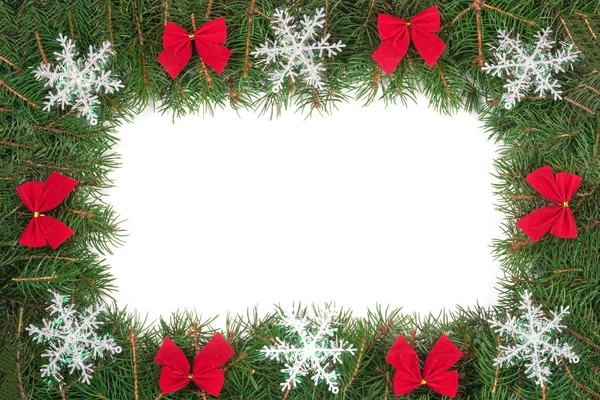 Moldura de Natal feita de ramos de abeto decorados com arcos e flocos de neve isolados no fundo branco — Fotografia de Stock