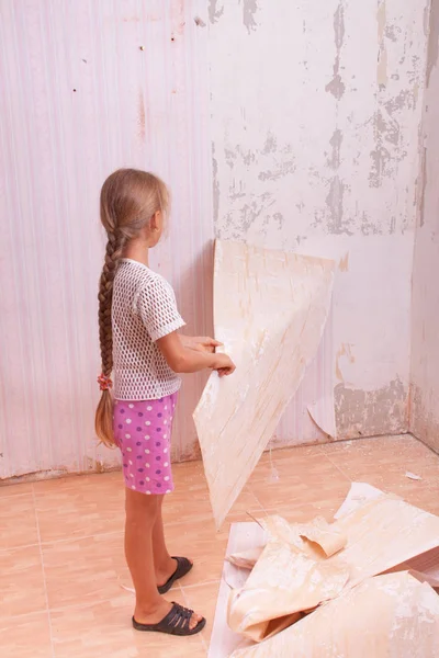 girl remove old wallpapers from wall