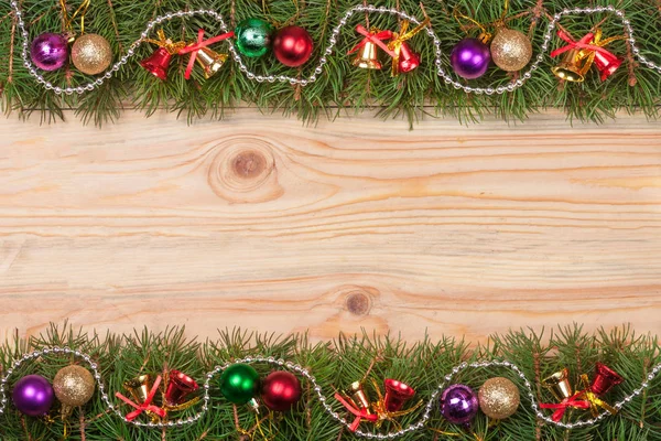 Χριστουγεννιάτικο καρέ από κλαδιά έλατου διακοσμημένο με χάντρες κουδούνια και μπάλες σε ανοιχτόχρωμο φόντο ξύλινη — Φωτογραφία Αρχείου