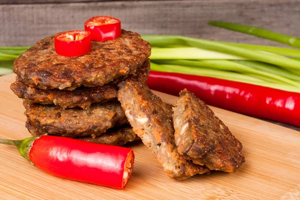 karaciğer krep veya pirzola chili biber ve ahşap bir zemin üzerine yeşil soğan ile