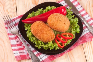 iki kızarmış ekmekli göğsü siyah plaka ve ahşap arka plan marul ile