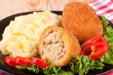 üç kızarmış ekmekli göğsü siyah plaka ve ahşap arka plan marul patates püresi ile