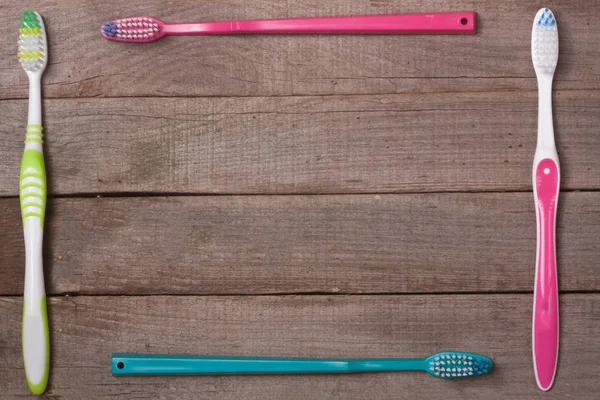 Frame of manual toothbrushes on the old wooden background top view — Stock Photo, Image