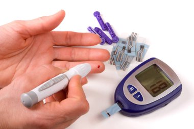 Beyaz arka plan üzerinde izole bir el ile kan şekeri ölçüm cihazı