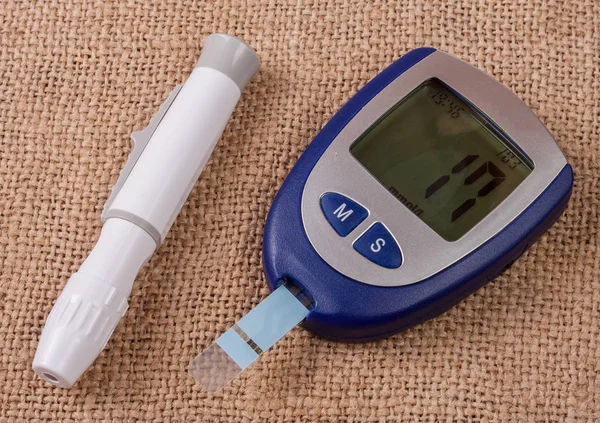 The blood glucose meter on the background of burlap — Stock Photo, Image