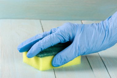 Lastik eldiven bir ahşap zemin üzerine sünger ile el