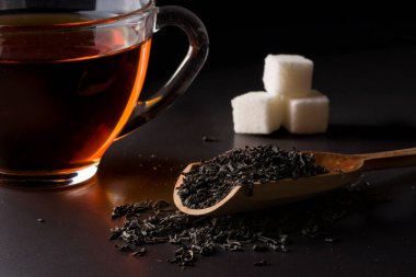 çay süzgeci ile bir fincan koyu arka plan üzerinde