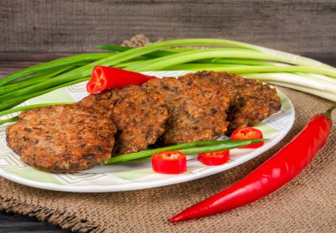 karaciğer krep veya pirzola chili biber ve ahşap bir zemin üzerine yeşil soğan ile