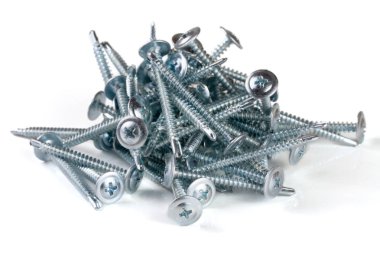 Beyaz arkaplanda izole edilmiş metal vidalar yığını
