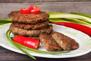 karaciğer krep veya pirzola chili biber ve ahşap bir zemin üzerine yeşil soğan ile