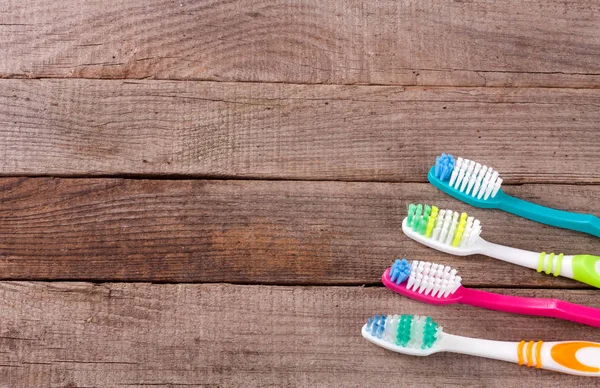 Manual toothbrushes on the old wooden background top view — Stock Photo, Image