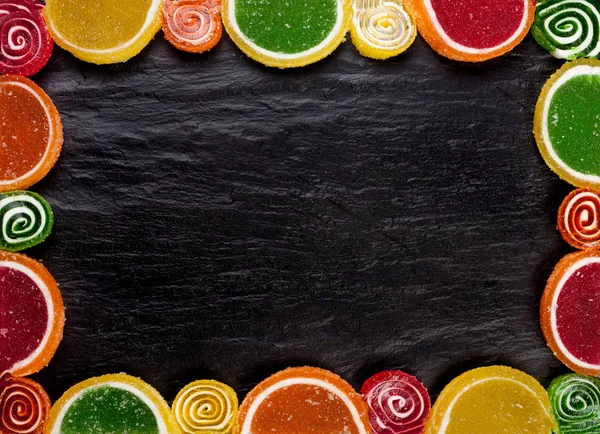 Marco de gelatinas de frutas sobre un fondo oscuro. Vista superior con espacio de copia — Foto de Stock