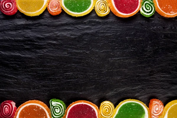 Marco de gelatinas de frutas sobre un fondo oscuro. Vista superior con espacio de copia — Foto de Stock