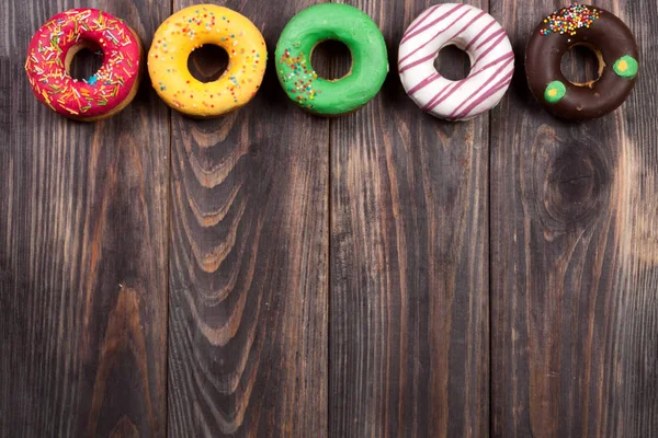 Glazed donuts on a black wooden background with copy space for your text. Top view — Stock Photo, Image