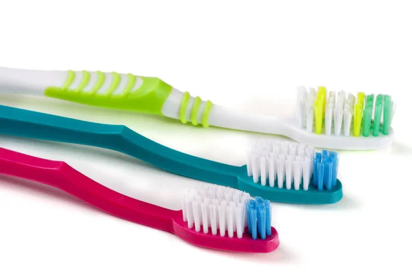 Três escovas de dentes isoladas em um fundo branco close-up — Fotografia de Stock