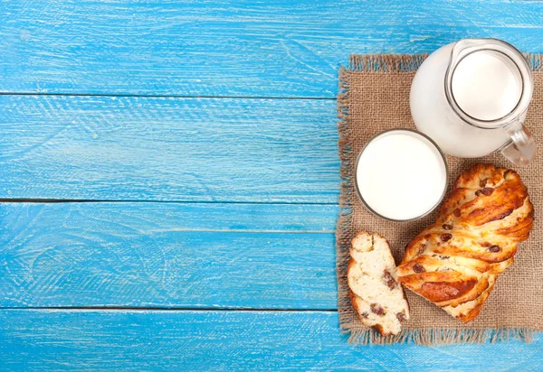 Kancsó és pohár tejet és egy vekni kenyeret hely másol a szöveg kék fa alapon. Szemközti nézet — Stock Fotó