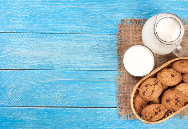 Sürahi ve bardak süt ile yulaf ezmeli kurabiye kopya alanı metniniz için mavi bir ahşap zemin üzerine. Üstten Görünüm — Stok fotoğraf