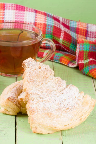 Két puff cookie-kat, egy csésze tea a zöld fa háttér — Stock Fotó