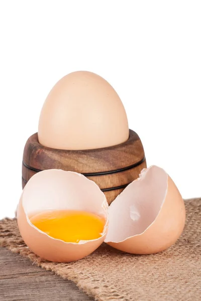 Ei in einer hölzernen Schüssel auf einem Brett mit Säcken auf weißem Hintergrund — Stockfoto