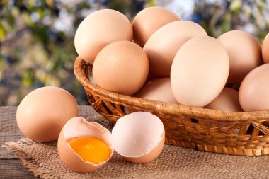 Bahçe arka plan bulanık ile ahşap bir gemide bir hasır sepet yumurta