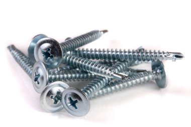 Beyaz arkaplanda izole edilmiş metal vidalar yığını