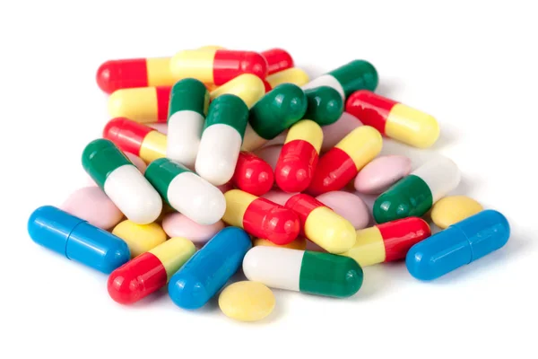 กองของยาที่มีสีสันแยกกันบนพื้นหลังสีขาว — ภาพถ่ายสต็อก