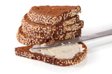 Susam ve beyaz arka plan üzerinde izole tereyağı ile siyah ekmek dilimleri