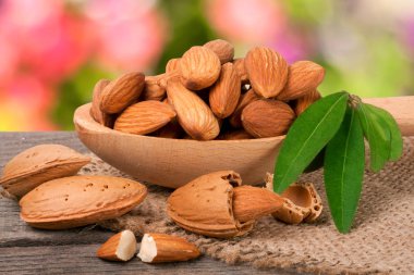 soyulmuş badem ile bir tahta kaşık masada yaprak yığını Bahçe arka plan bulanık