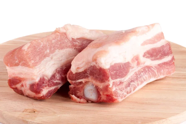 Morceaux de porc sur une planche à découper isolés sur fond blanc — Photo