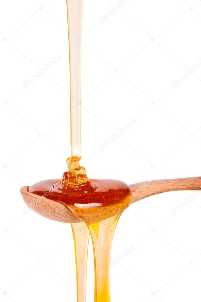 Honey in a wooden spoon isolated on a white background