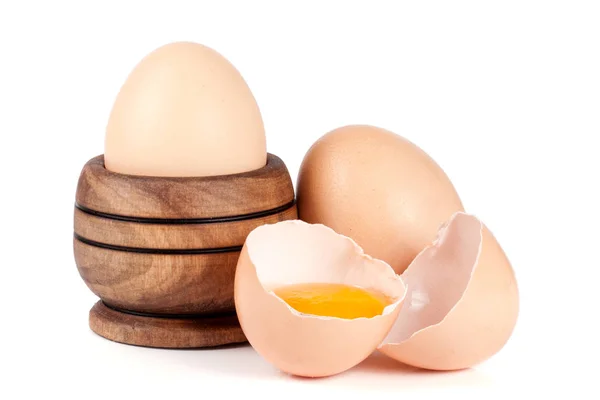 Twee hele eieren en gebroken ei in een houten kom geïsoleerd op witte achtergrond — Stockfoto