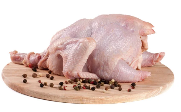 Karkas surowego kurczaka z pieprzu na na białym tle deska do krojenia — Zdjęcie stockowe