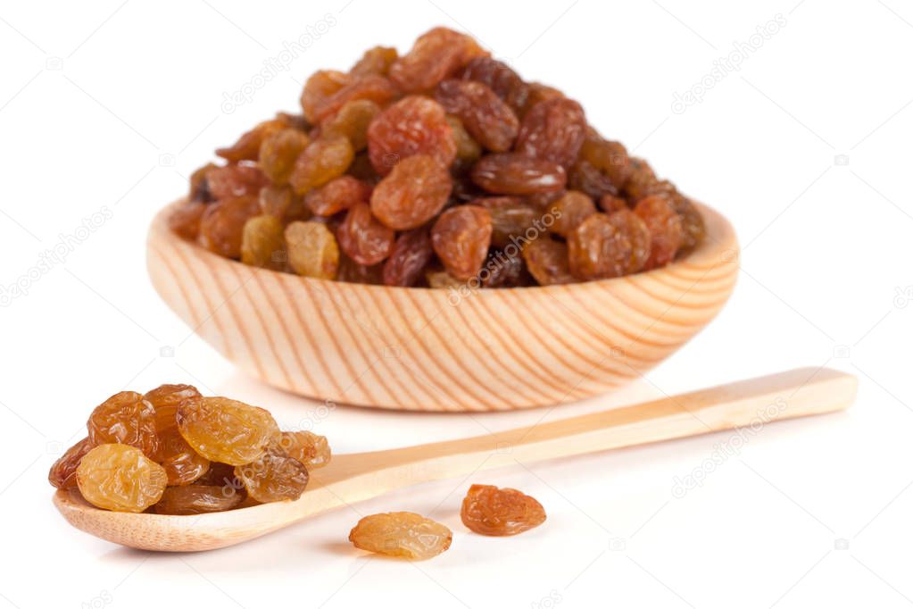 raisins in a wooden bowl with spoon isolated on white background