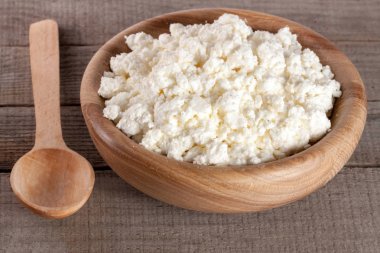 Eski ahşap zemin üzerine ahşap bir kase süzme peynir