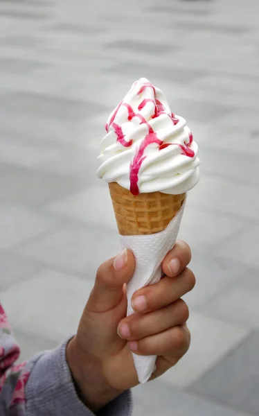white ice cream cone with wafer in the hand
