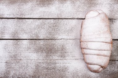 bir kruvasan kopya alanı metniniz için eski ahşap zemin üzerine pudra şekeri serpilir. Üstten Görünüm