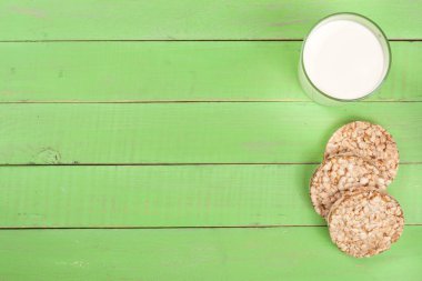 bir bardak süt ile tahıl crispbreads kopya alanı metniniz için yeşil bir ahşap zemin üzerine. Üstten Görünüm