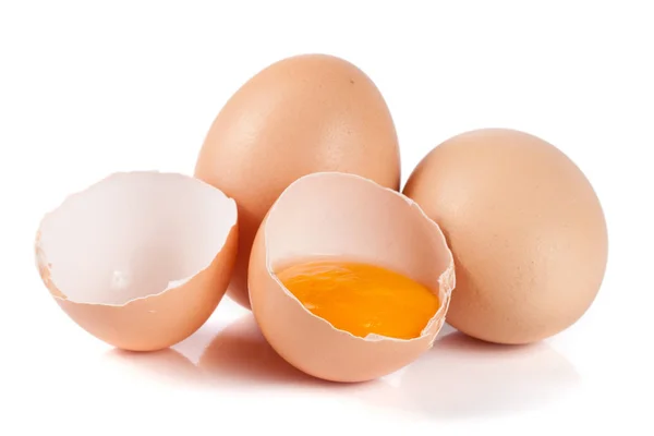 Due uova intere e uova rotte isolate su fondo bianco — Foto Stock