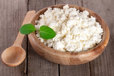 Eski ahşap zemin üzerine ahşap bir kase süzme peynir