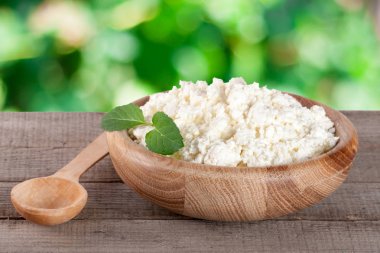 Bahçe arka plan bulanık gemide ahşap bir kase süzme peynir